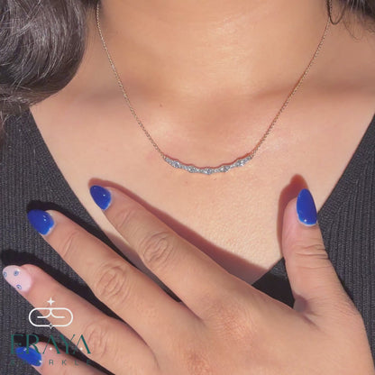 Video view of wave diamond bar necklace in hand, showing curved bar, round diamonds, and gold chain from all angles
